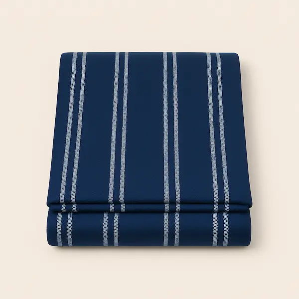Folded navy blue throw blanket with white vertical stripes on neutral background